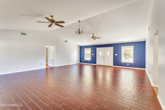 unfurnished living room featuring ceiling fan with notable chandelier and vaulted ceiling