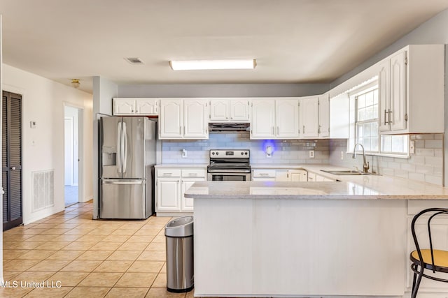 kitchen with sink, light tile patterned floors, decorative backsplash, white cabinets, and appliances with stainless steel finishes