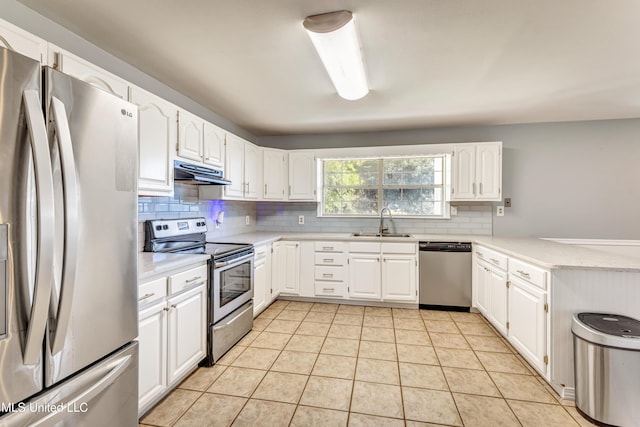 kitchen with backsplash, sink, light tile patterned floors, appliances with stainless steel finishes, and white cabinetry