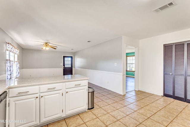 kitchen with a wealth of natural light, white cabinetry, ceiling fan, and light tile patterned flooring