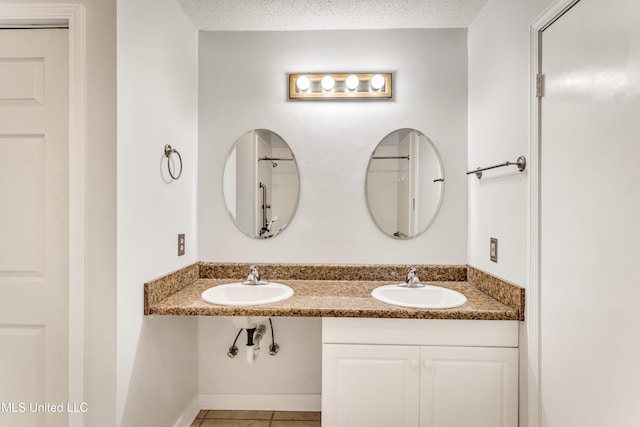 bathroom featuring tile patterned floors, sink, and a textured ceiling