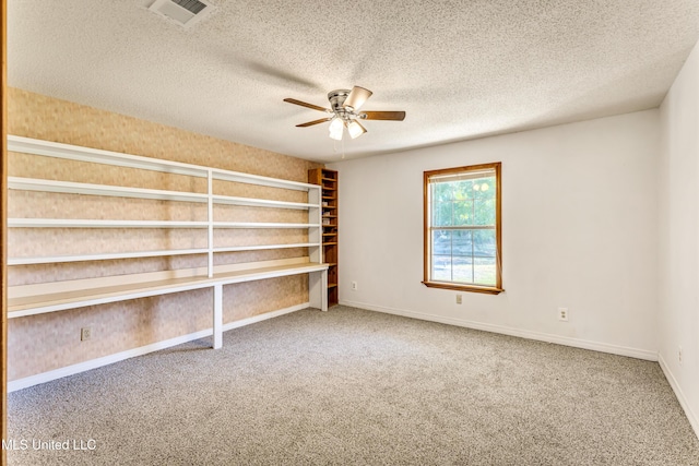 spare room featuring carpet flooring, ceiling fan, and a textured ceiling