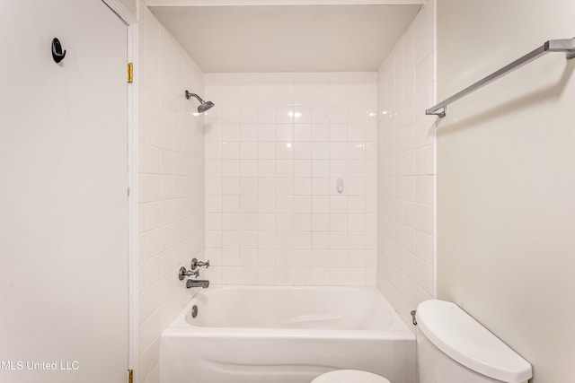 bathroom with tiled shower / bath combo and toilet