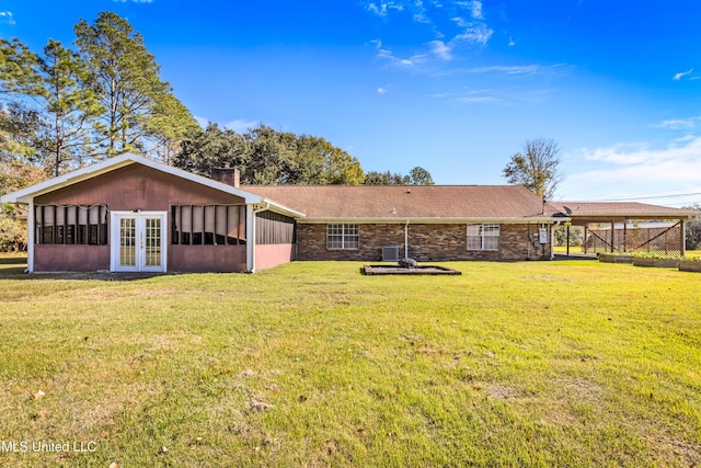 view of yard featuring a sunroom and french doors