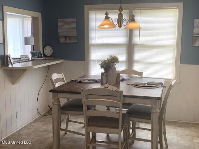 2145 Second St, Natchez, MS 39120 - dining area with a wainscoted wall, a chandelier, and a decorative wall