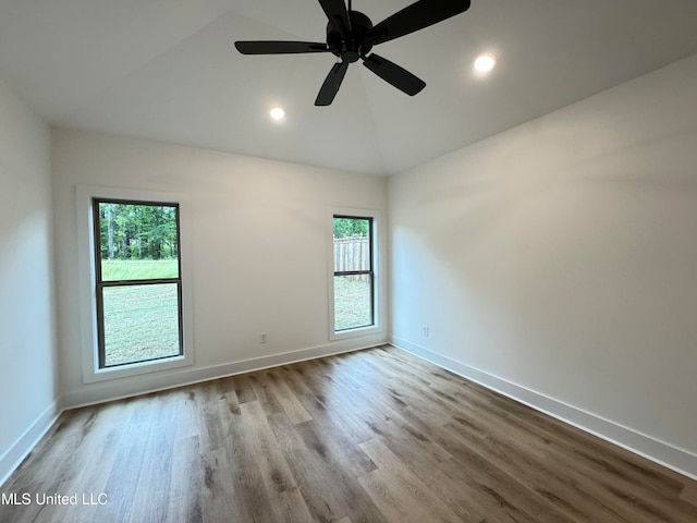 empty room with a wealth of natural light, lofted ceiling, light wood-type flooring, and ceiling fan