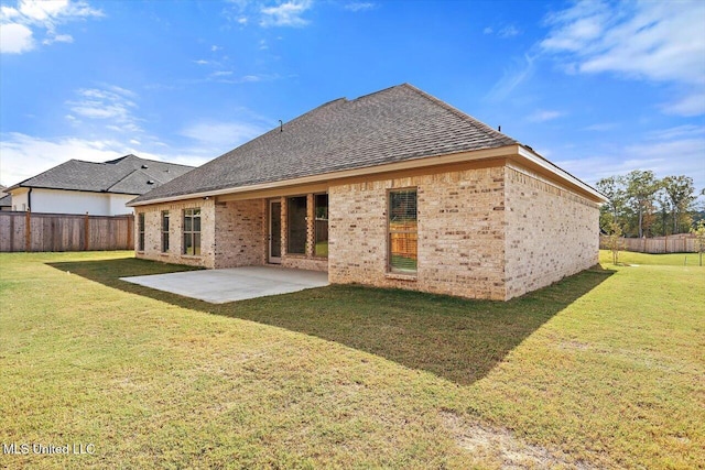 rear view of property with a patio and a lawn