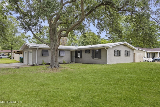 single story home featuring concrete driveway, an attached garage, a front yard, brick siding, and metal roof
