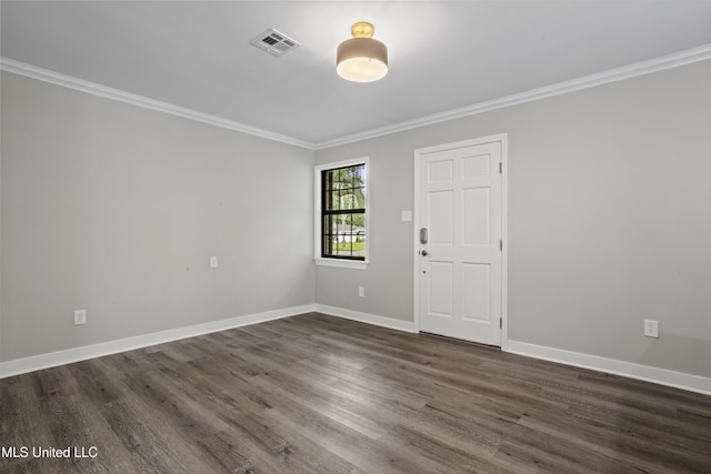 empty room featuring ornamental molding, dark wood-style flooring, and baseboards