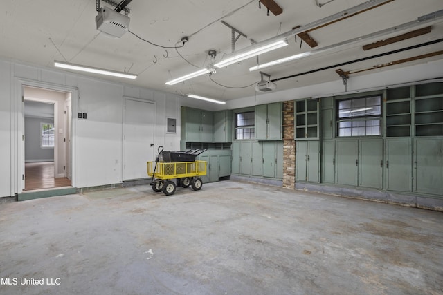 garage with a garage door opener and electric panel