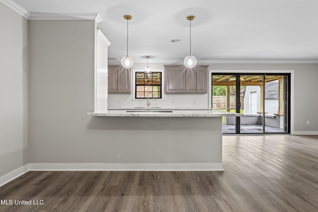 kitchen featuring ornamental molding, baseboards, light countertops, dark wood-style flooring, and tasteful backsplash