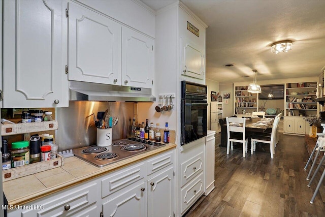 9414 Hillsboro Ludlow Rd, Lena, MS 39094 - kitchen featuring oven, stainless steel electric stovetop, under cabinet range hood, tile countertops, and white cabinets