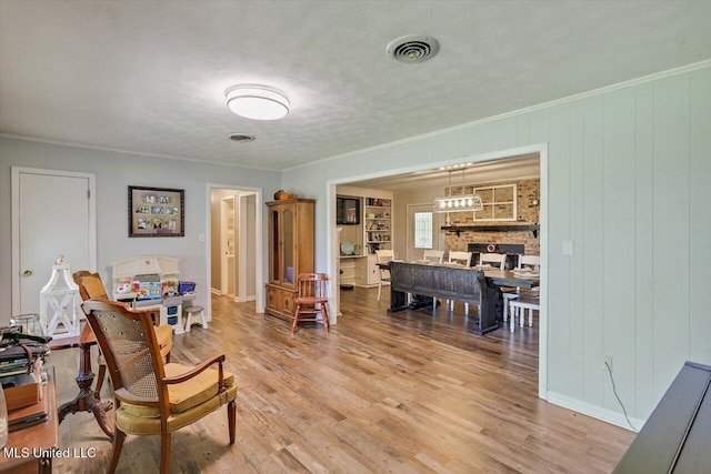 9414 Hillsboro Ludlow Rd, Lena, MS 39094 - living area with light wood-type flooring, a stone fireplace, and a textured ceiling