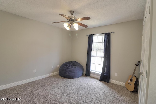 misc room featuring ceiling fan, light colored carpet, and a textured ceiling