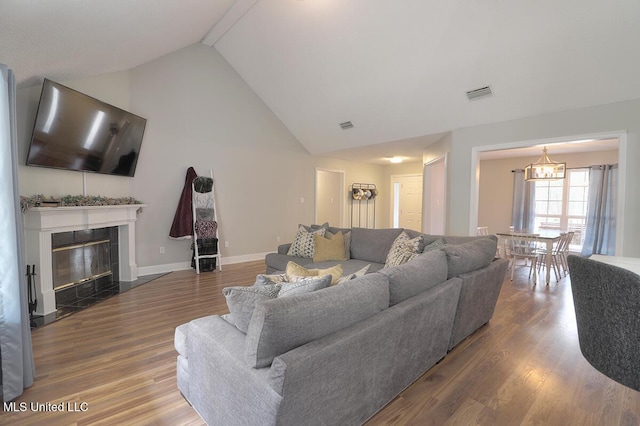 living room featuring hardwood / wood-style flooring, a high end fireplace, and high vaulted ceiling