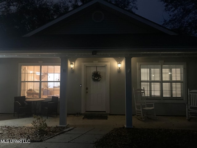 exterior entry at night featuring a patio