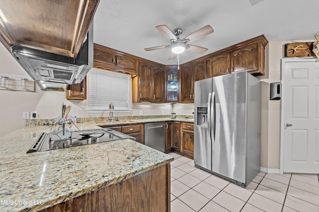 kitchen featuring light stone countertops, light tile patterned floors, sink, kitchen peninsula, and stainless steel appliances