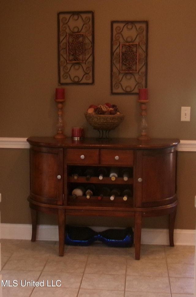 bar area with baseboards and light tile patterned floors