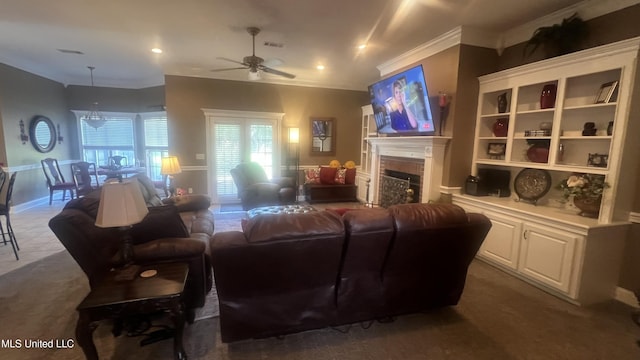 living area featuring a ceiling fan, a fireplace, crown molding, and dark carpet