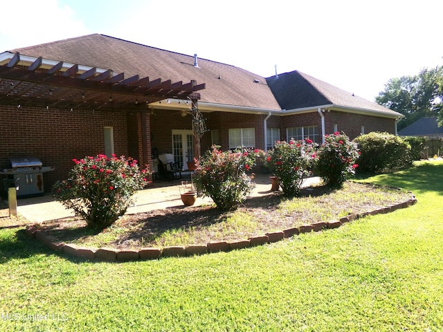 back of house with a patio, a pergola, brick siding, a yard, and french doors
