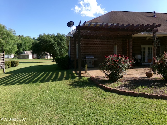 view of green lawn with a pergola, a patio, and french doors