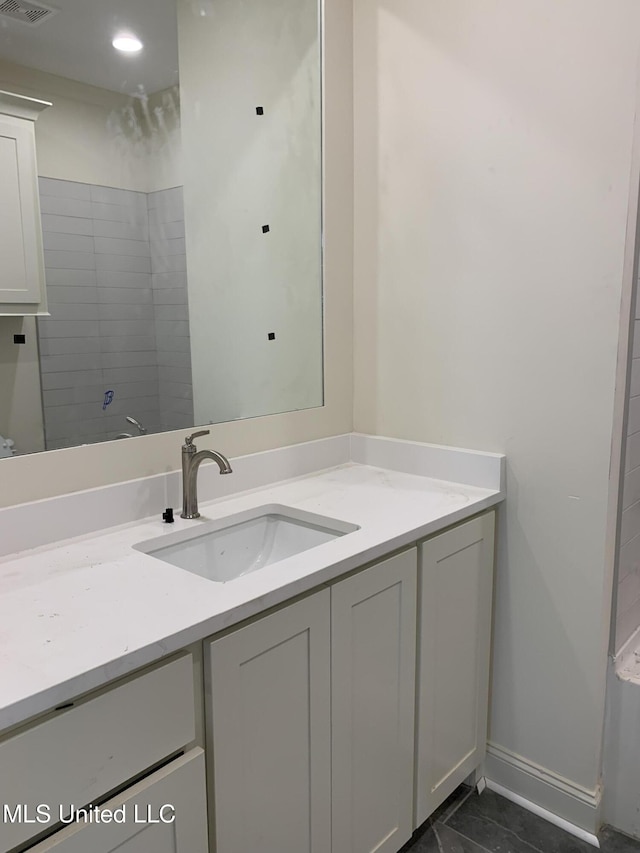 bathroom featuring tile patterned floors, vanity, and walk in shower