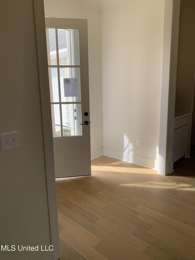 doorway with hardwood / wood-style flooring and a healthy amount of sunlight