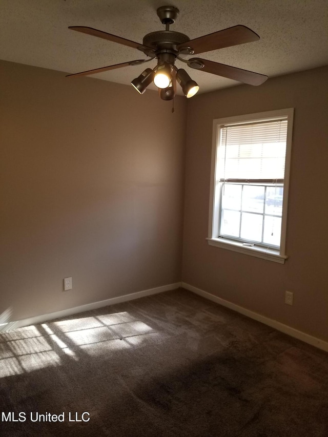 carpeted spare room featuring a textured ceiling and ceiling fan