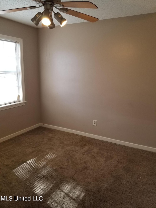 carpeted empty room with ceiling fan and a textured ceiling