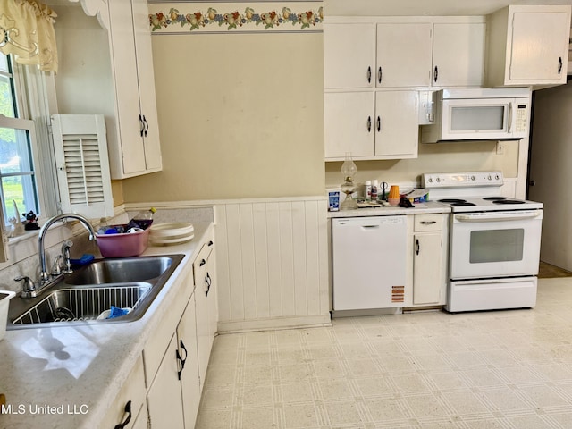 4425 Oak Ave, Moss Point, MS 39563 - kitchen with white appliances, light countertops, wainscoting, white cabinetry, and light flooring