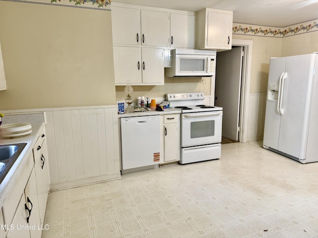 4425 Oak Ave, Moss Point, MS 39563 - kitchen featuring white appliances, a wainscoted wall, white cabinets, light countertops, and light floors