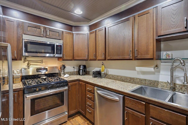 kitchen featuring wooden ceiling, recessed lighting, stainless steel appliances, a sink, and light stone countertops