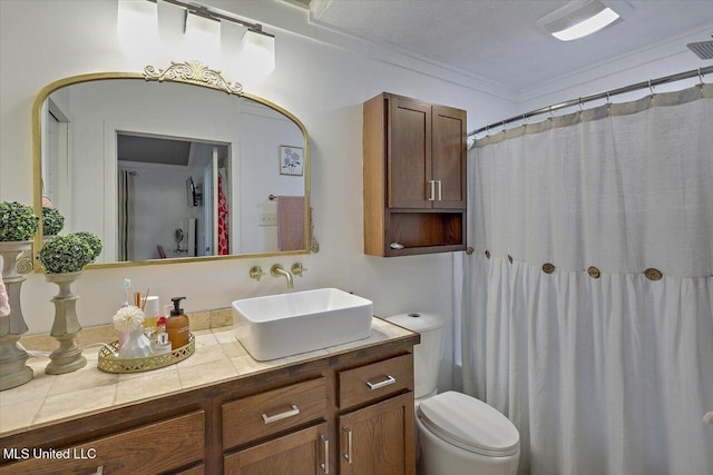 full bathroom with toilet, visible vents, ornamental molding, and vanity