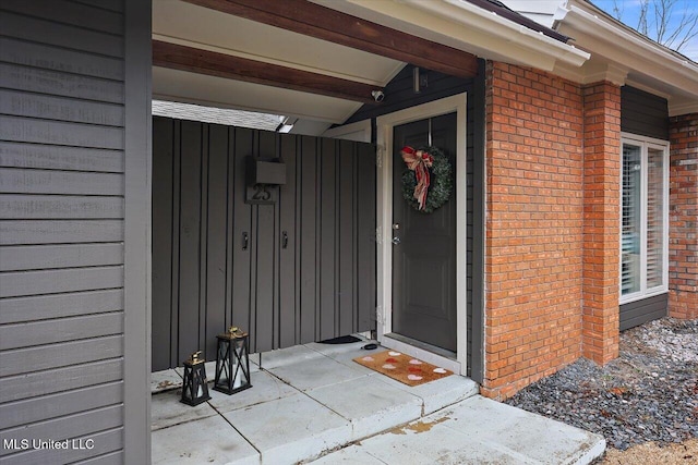 view of exterior entry featuring brick siding