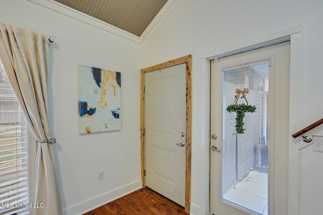 entrance foyer with dark wood-style floors, lofted ceiling, ornamental molding, and baseboards