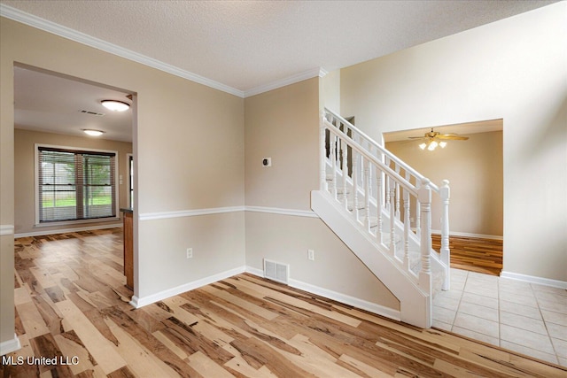 9015 Champlain Dr, Olive Branch, MS 38654 - empty room with wood finished floors, stairway, a textured ceiling, baseboards, and ornamental molding
