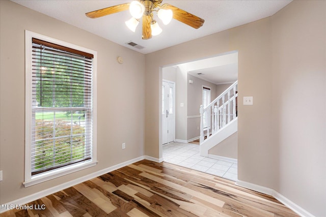 9015 Champlain Dr, Olive Branch, MS 38654 - empty room featuring wood finished floors, stairs, baseboards, and ceiling fan