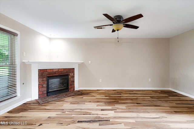 9015 Champlain Dr, Olive Branch, MS 38654 - unfurnished living room featuring wood finished floors, a brick fireplace, a ceiling fan, and baseboards