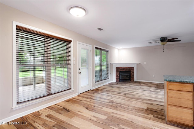 9015 Champlain Dr, Olive Branch, MS 38654 - unfurnished living room with baseboards, light wood finished floors, a fireplace, and a ceiling fan