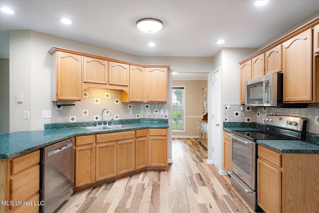 9015 Champlain Dr, Olive Branch, MS 38654 - kitchen featuring stainless steel appliances, a sink, light wood-type flooring, tasteful backsplash, and light brown cabinets