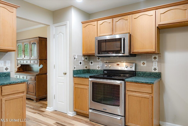 9015 Champlain Dr, Olive Branch, MS 38654 - kitchen featuring stainless steel appliances, dark countertops, light wood-type flooring, light brown cabinets, and crown molding