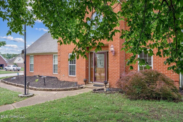 9015 Champlain Dr, Olive Branch, MS 38654 - view of front facade featuring brick siding, roof with shingles, and a front lawn