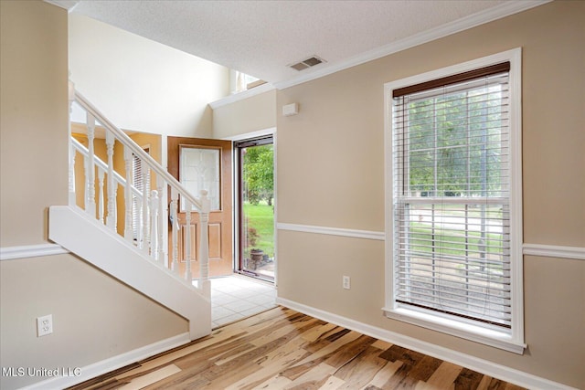 9015 Champlain Dr, Olive Branch, MS 38654 - foyer entrance featuring healthy amount of natural light, stairs, wood finished floors, ornamental molding, and a textured ceiling