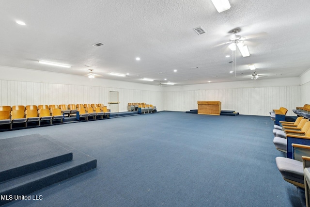 miscellaneous room featuring dark colored carpet and a textured ceiling