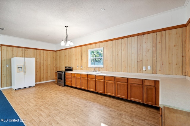 kitchen with sink, white fridge with ice dispenser, light hardwood / wood-style flooring, pendant lighting, and stainless steel range with electric stovetop