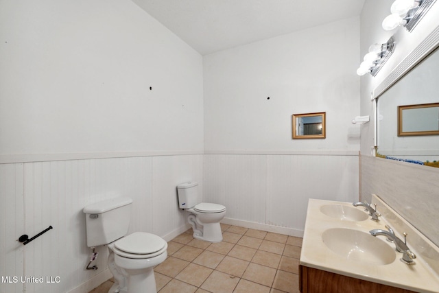 bathroom featuring tile patterned floors, vanity, toilet, and vaulted ceiling