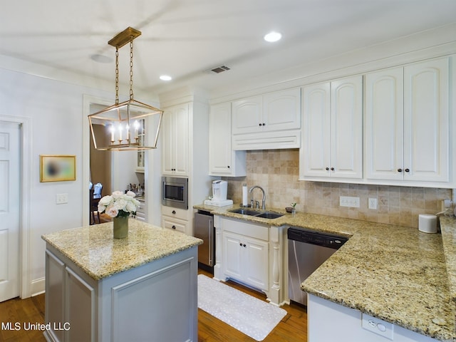 kitchen featuring white cabinets, a kitchen island, sink, and stainless steel appliances