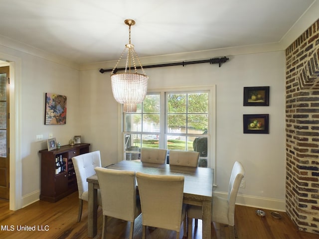 dining room featuring a notable chandelier, wood-type flooring, and ornamental molding