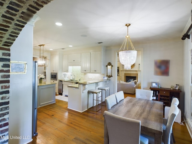 dining area featuring hardwood / wood-style floors, a notable chandelier, and sink