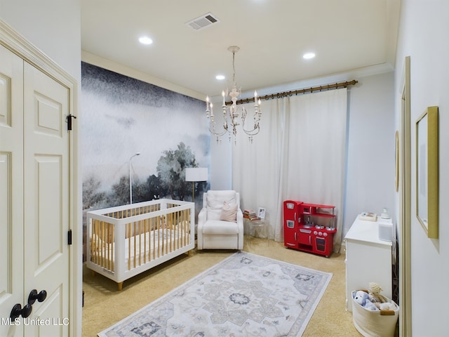 carpeted bedroom with a chandelier, crown molding, and a nursery area